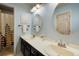 Well-lit bathroom featuring a double sink vanity and pastel blue walls at 2061 Chesapeake Pl, Highlands Ranch, CO 80126
