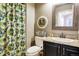 Charming bathroom with a decorative shower curtain, framed mirror, and neutral tones at 2061 Chesapeake Pl, Highlands Ranch, CO 80126