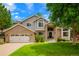 Charming two-story home with a brick facade, lush lawn, and well-maintained landscaping at 2061 Chesapeake Pl, Highlands Ranch, CO 80126