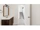 Hallway view of a charming bathroom vanity, stairs and open doorway leading to the next room at 9685 W Chatfield Ave # A, Littleton, CO 80128