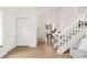 Inviting entry with a view of dining area, showcasing staircase, wood floors, and ample natural light at 9685 W Chatfield Ave # A, Littleton, CO 80128