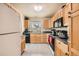 Functional kitchen featuring updated appliances, light wood cabinets, and tiled flooring at 2146 S Scranton Way, Aurora, CO 80014