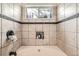 Well-kept bathroom with tiled shower with a window and toiletries storage niche at 2146 S Scranton Way, Aurora, CO 80014