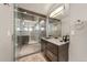 Modern bathroom featuring a glass shower, tiled walls and flooring, with stylish vanity and contemporary fixtures at 1730 W 67Th Ave, Denver, CO 80221