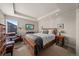 Cozy bedroom features a tray ceiling, plush armchair, wood furniture, and a comfortable bed with gray accents at 1730 W 67Th Ave, Denver, CO 80221