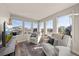 Bright living room boasts large windows, comfortable seating, neutral color palette, and an entertainment center at 1730 W 67Th Ave, Denver, CO 80221