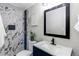Modern bathroom features a stylish vanity and shower with white marble-patterned tile and bronze fixtures at 9280 Russell Way, Thornton, CO 80229