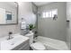 Bathroom features gray tiling, a bathtub, and a modern vanity with chrome fixtures at 9280 Russell Way, Thornton, CO 80229