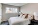 Cozy bedroom with neutral tones, large window, and modern bedside lamps at 9280 Russell Way, Thornton, CO 80229