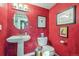 Charming powder room with red walls and pedestal sink at 6324 S Grape Ct, Centennial, CO 80121