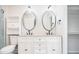 Bright bathroom with a dual sink vanity, modern fixtures, and built in shelves at 4760 S Wright Way, Morrison, CO 80465