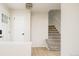 Inviting entryway with hardwood floors, white trim, modern lighting and access to the carpeted staircase at 4760 S Wright Way, Morrison, CO 80465