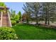 Spacious backyard featuring lush green grass, mature trees, and a charming swing for outdoor relaxation and enjoyment at 20182 E Maplewood Pl, Centennial, CO 80016