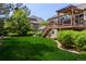 A well-maintained backyard with a large wooden deck, lush green lawn, and a pergola offering a serene outdoor space at 20182 E Maplewood Pl, Centennial, CO 80016