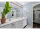 Bright bathroom featuring double sinks with white countertops and cabinets plus decorative wall art at 20182 E Maplewood Pl, Centennial, CO 80016