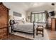 Comfortable main bedroom with wood floors and tray ceiling with decorative lamps at 20182 E Maplewood Pl, Centennial, CO 80016