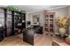 Well-lit office space with hardwood floors, built-in bookshelves, and decorative cabinet at 20182 E Maplewood Pl, Centennial, CO 80016