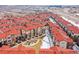 The townhome community is shown from an aerial view, with red roofs, a community lawn and walking paths at 8421 Galvani Trl # E, Littleton, CO 80129