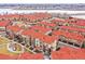 Aerial shot showcases the community's townhomes, landscaping, and proximity to a serene lake at 8421 Galvani Trl # E, Littleton, CO 80129