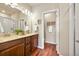 Bathroom with double vanity, dark wood cabinets and a separate toilet room at 8421 Galvani Trl # E, Littleton, CO 80129