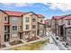 View of multi-story townhomes with well-kept landscaping at 8421 Galvani Trl # E, Littleton, CO 80129