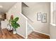 Hallway featuring stairs with gray carpet, wood flooring, and stylish decorations at 8421 Galvani Trl # E, Littleton, CO 80129
