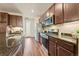 Stylish kitchen featuring stainless steel appliances, granite countertops, and dark wood cabinetry at 8421 Galvani Trl # E, Littleton, CO 80129