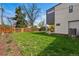 Well-manicured backyard with green lawn, wood fence, storage shed, and patio, creating a serene outdoor retreat at 1220 S Elm St, Denver, CO 80246
