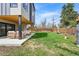 Spacious backyard with a covered patio, lush green grass, and a privacy fence at 1220 S Elm St, Denver, CO 80246