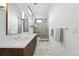 Modern bathroom featuring double sinks, white counter tops, decorative tiled shower, and hexagon tile floors at 1220 S Elm St, Denver, CO 80246
