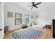 Bright bedroom featuring hardwood floors, modern ceiling fan, two large windows, and neutral paint at 1220 S Elm St, Denver, CO 80246