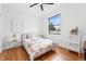 Bright bedroom featuring hardwood floors, modern ceiling fan, and large window at 1220 S Elm St, Denver, CO 80246