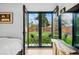 Bedroom with backyard access features a comfortable bed, TV, and glass doors at 1220 S Elm St, Denver, CO 80246