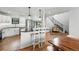 Modern kitchen featuring a marble island, white cabinets, hardwood floors, and seamless flow to the dining area at 1220 S Elm St, Denver, CO 80246