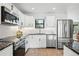Modern kitchen showcasing white cabinets, stainless steel appliances, and sleek black countertops at 1220 S Elm St, Denver, CO 80246