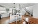 Modern kitchen featuring a marble island, white cabinets, hardwood floors, and seamless flow to the dining area at 1220 S Elm St, Denver, CO 80246
