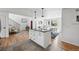Spacious kitchen with modern island flows into dining and living areas, showcasing hardwood floors and natural light at 1220 S Elm St, Denver, CO 80246