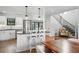 Bright and modern kitchen with island, hardwood floors, white cabinets, and stainless steel appliances at 1220 S Elm St, Denver, CO 80246
