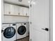 Laundry room with modern appliances, white cabinets, folding counter, and tile flooring at 1220 S Elm St, Denver, CO 80246