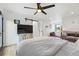 Bright main bedroom features wood floors, ceiling fan, sitting area, and sliding barn door at 1220 S Elm St, Denver, CO 80246