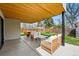 Inviting outdoor patio with stylish wicker furniture and wood ceiling, perfect for relaxing or entertaining guests at 1220 S Elm St, Denver, CO 80246