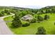 Aerial view of a well-maintained home on a spacious lot with lush green grass, mature trees and driveway at 5586 Colorow Dr, Morrison, CO 80465