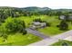 Wide aerial view of a beautiful home with mature landscaping, a spacious yard, and a long, winding driveway at 5586 Colorow Dr, Morrison, CO 80465