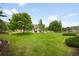 Expansive backyard featuring well-maintained lawn, mature trees, and a patio with seating, perfect for outdoor enjoyment at 5586 Colorow Dr, Morrison, CO 80465