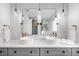 Modern bathroom with double sinks, sleek fixtures, herringbone backsplash, and pendant lighting at 5586 Colorow Dr, Morrison, CO 80465