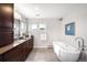 Bright bathroom with soaking tub, dark wood vanity, and a large window overlooking the outdoors at 5586 Colorow Dr, Morrison, CO 80465