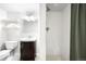 Cozy bathroom featuring a vanity, toilet, and shower with white tile surround and shelving at 5586 Colorow Dr, Morrison, CO 80465