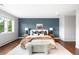 Comfortable bedroom features a textured accent wall, king bed, and hardwood floors at 5586 Colorow Dr, Morrison, CO 80465