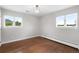 Light-filled bedroom with hardwood floors, radiator, and two windows showcasing outdoor views at 5586 Colorow Dr, Morrison, CO 80465