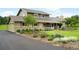 Well-maintained two-story home with landscaped flowerbeds, a paved driveway, and mature trees at 5586 Colorow Dr, Morrison, CO 80465